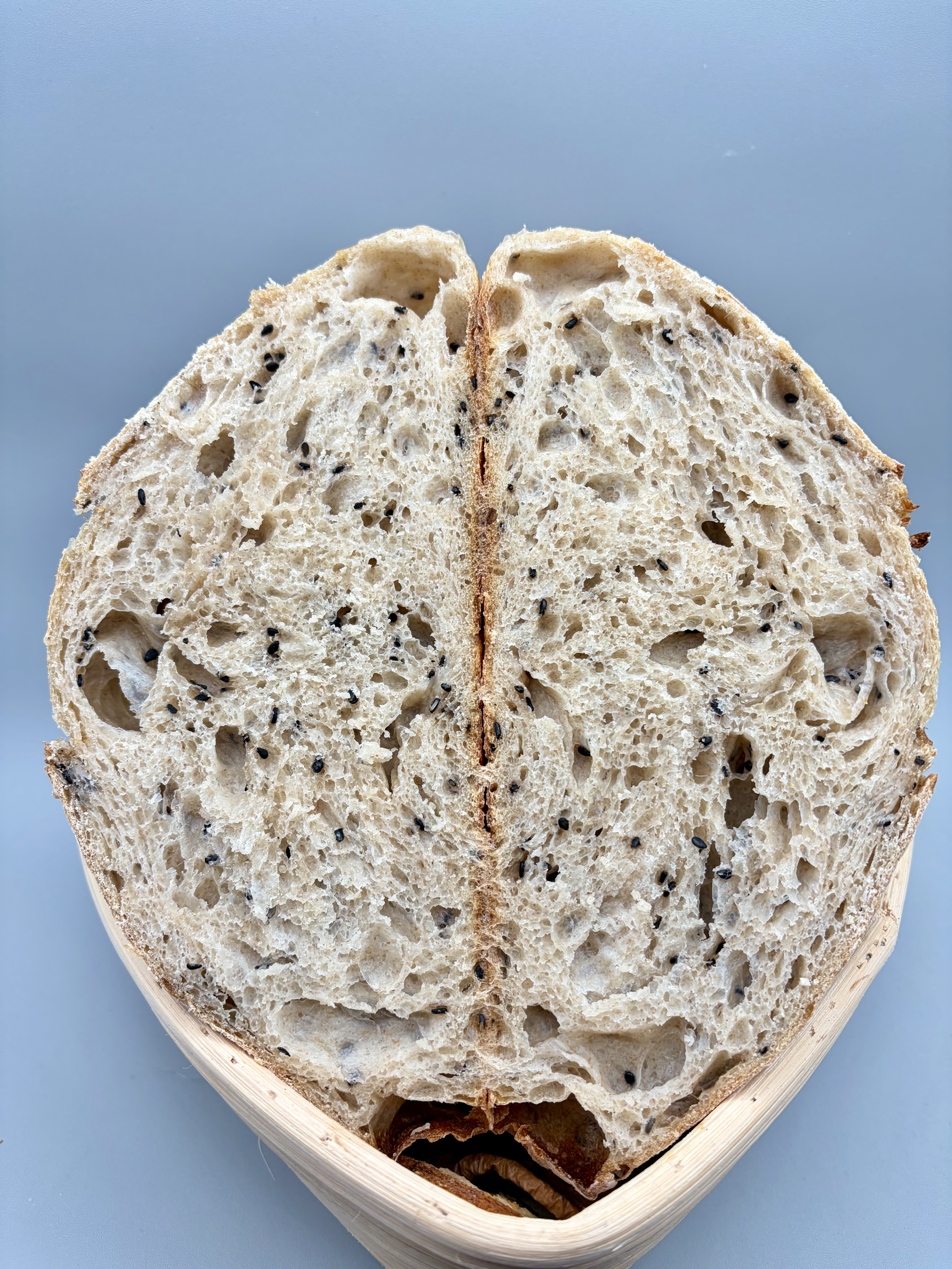 Cross-section of the poppy seed loaf showing open crumb with black sesame throughout